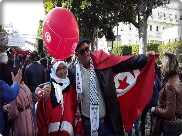 أعلام تونسية ترفرف هناك على أناشيد حزب حركة النهضة، وهنا على أهازيج دولة الخلافة لحزب التحرير
