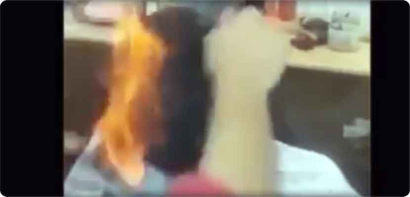 صورة من فيديو لحلاق هندي يحلق شعر الزبائن بإشعال النار في رؤوسهم
